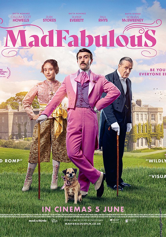 Henry Paget in a sumptuous pink suit poses between an elderly butler & a woman on the lawn outside a mansion.