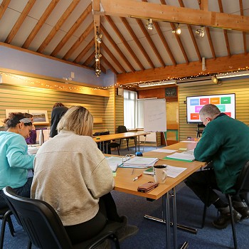 pobl oamgylch bwrddd yn gweithio